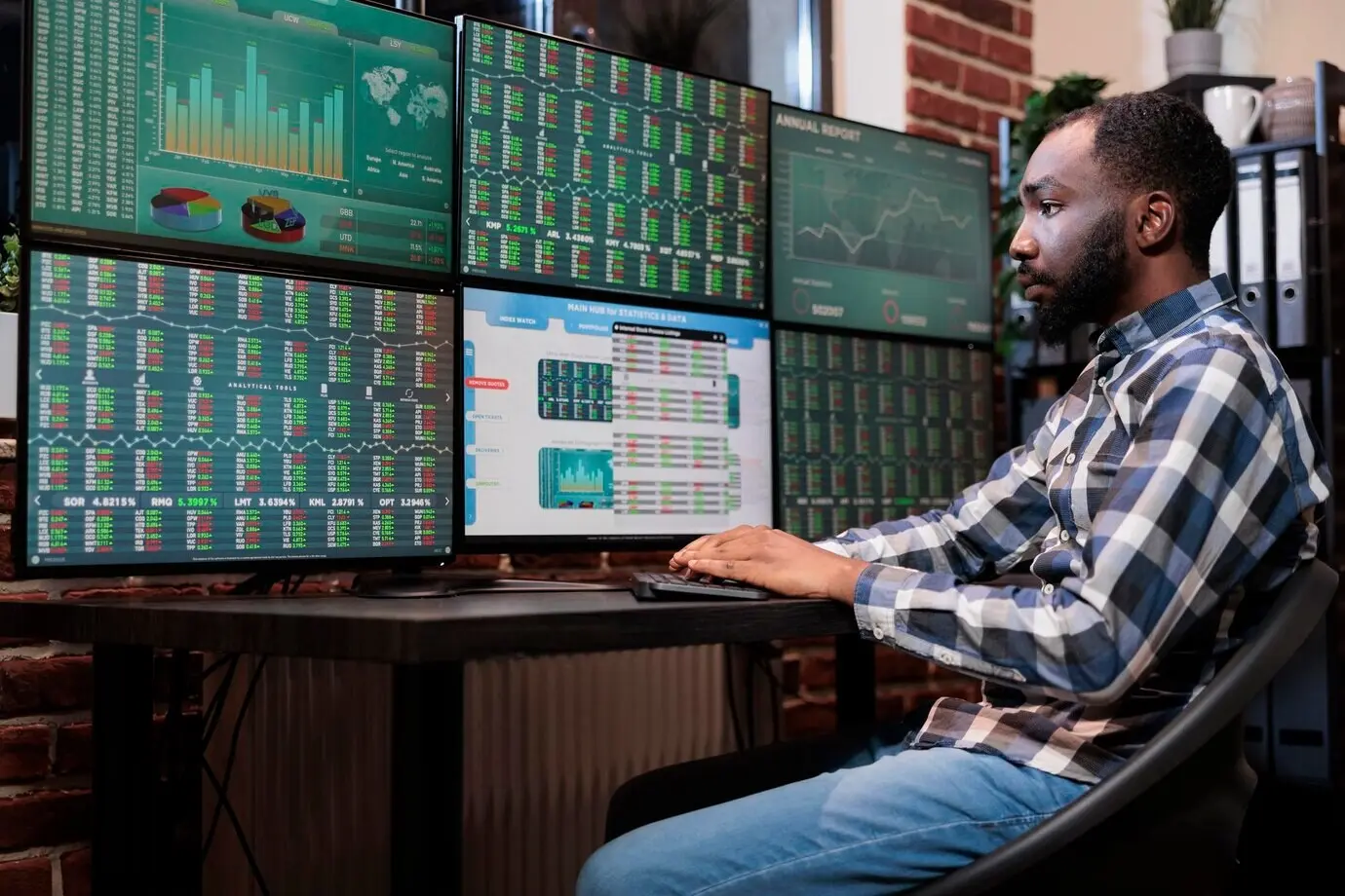 Employé d’une société de courtage assis à un poste de travail multi-écrans, négociant des actifs sans risque. Trader d’une société d’investissement utilisant une plateforme de change Forex et des statistiques en temps réel pour prédire la tendance du marché.