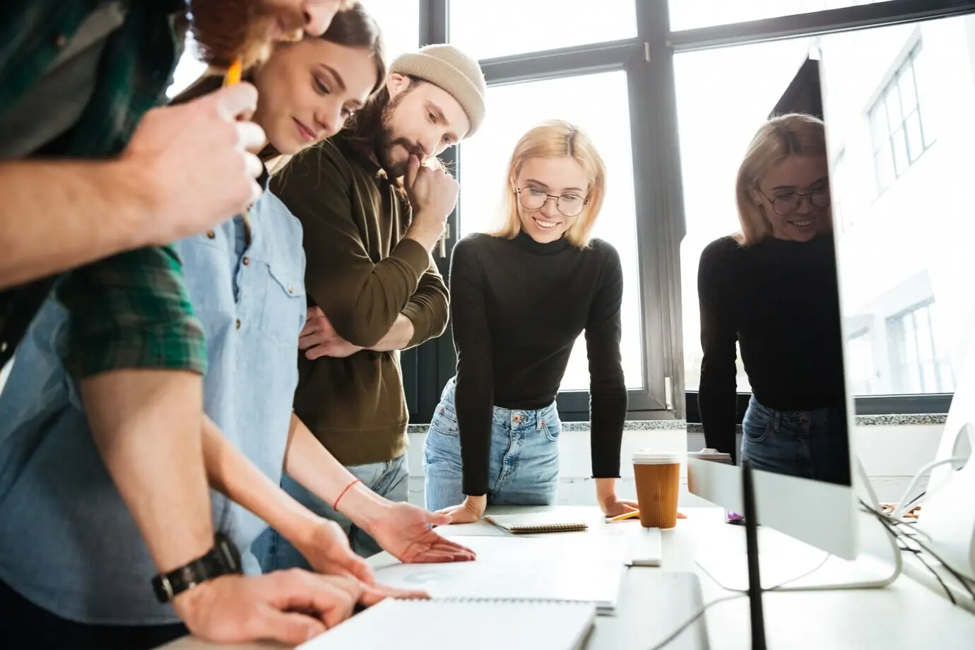 Des collègues concentrés debout dans un bureau.