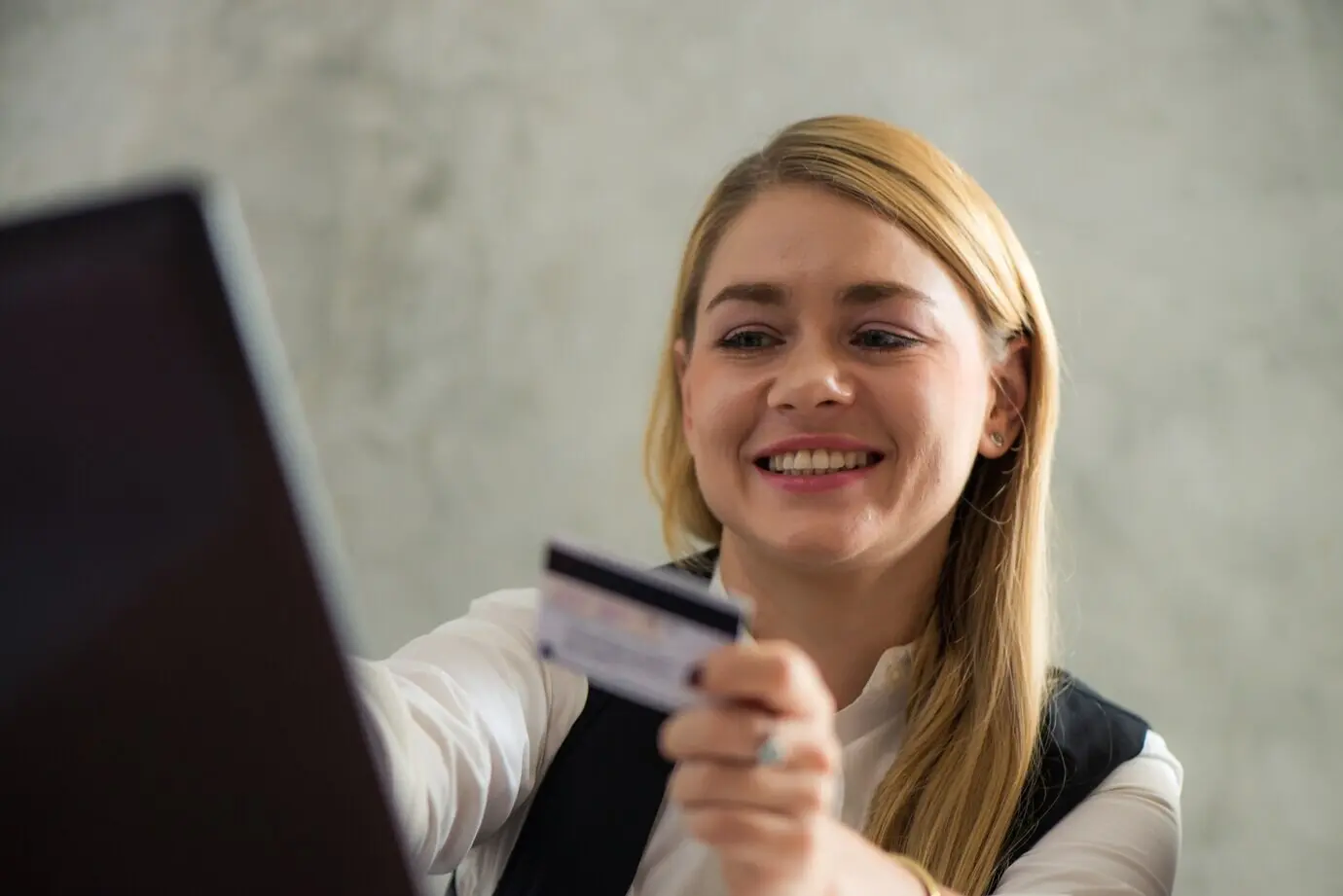 Jeune femme d’affaires tenant une carte de crédit et utilisant un ordinateur portable. Concept d’achat en ligne. Images avec un effet de style vintage.