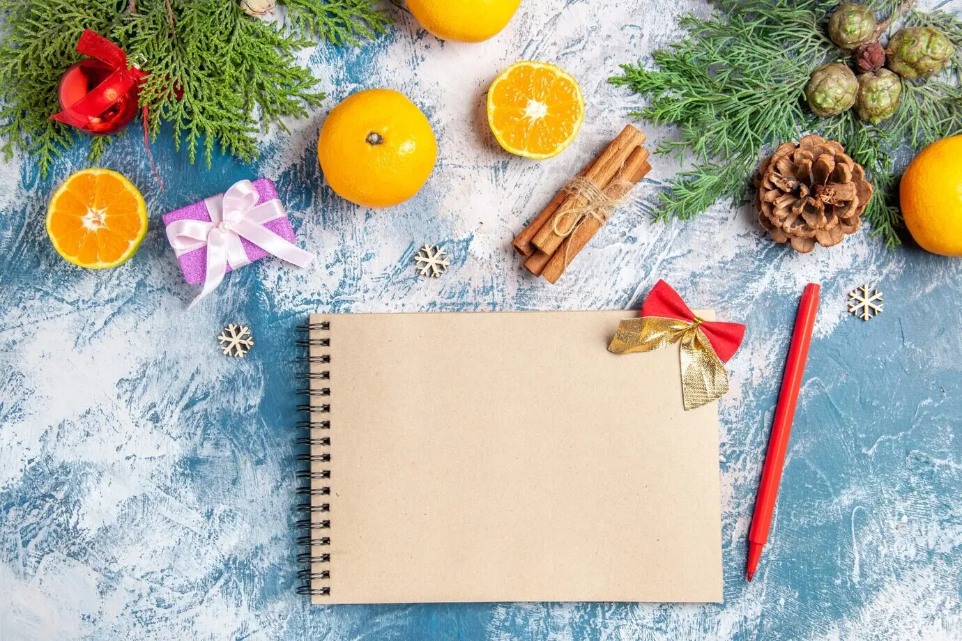 Vue de dessus de mandarines fraîches avec des cadeaux et un bloc-notes sur fond bleu.